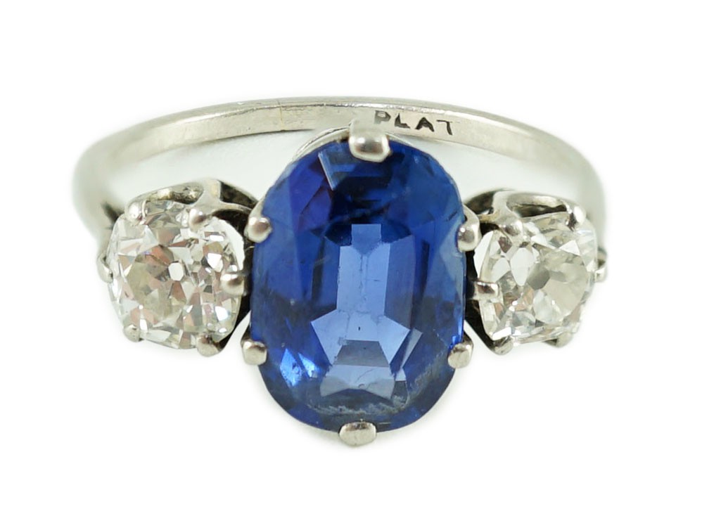 A mid 20th century platinum, single stone oval cut sapphire and two stone cushion cut diamond set dress ring